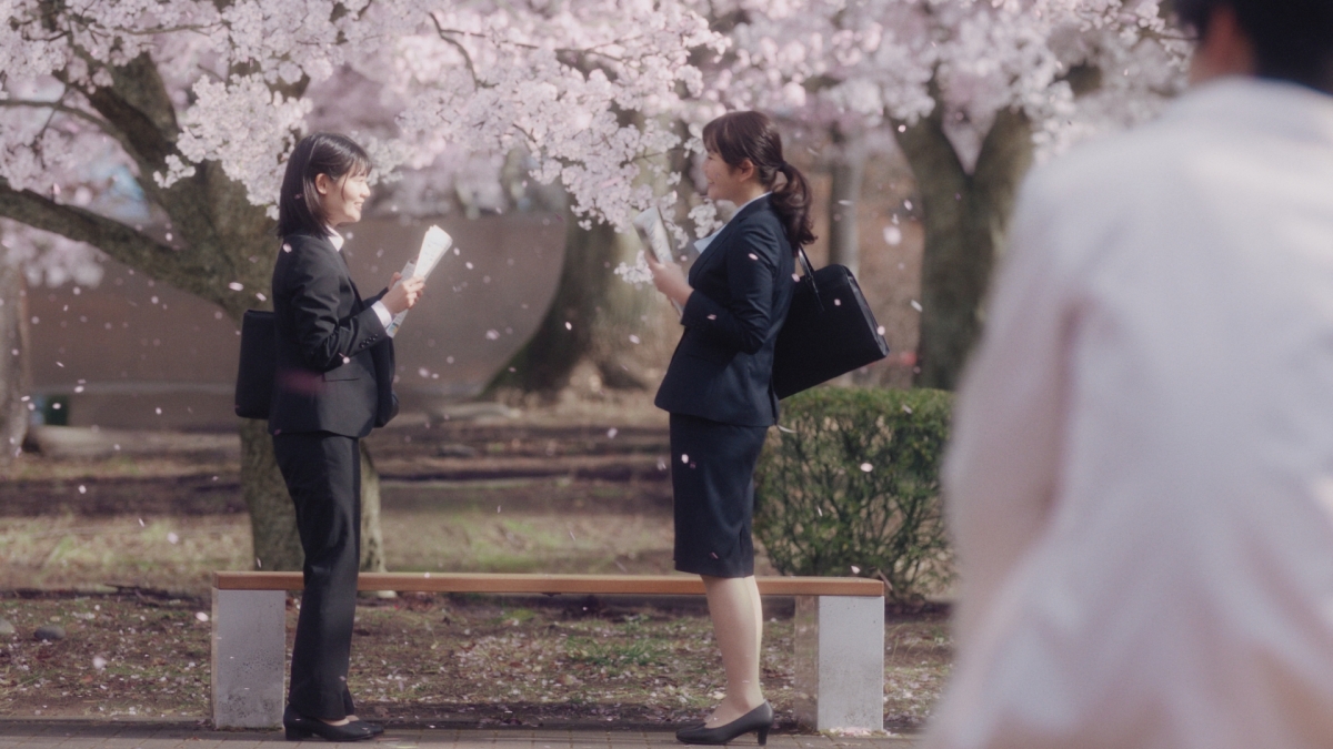 大学の先輩役の目黒蓮が満開の桜の中、新たな出会いを迎える新入生を見守り「ちょっと大人になった気分」