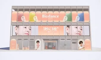 Biodanceの広告が掲載された建物の外観。入り口に人物。