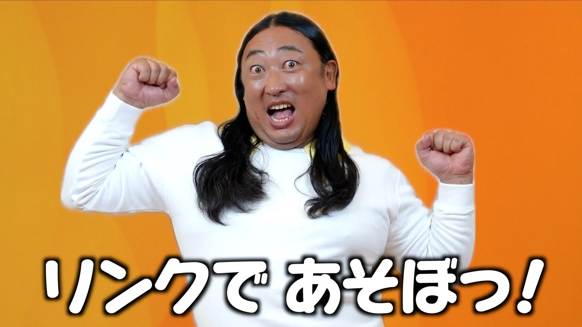 笑顔で両手を握りしめている男性（ロバート秋山さん）
