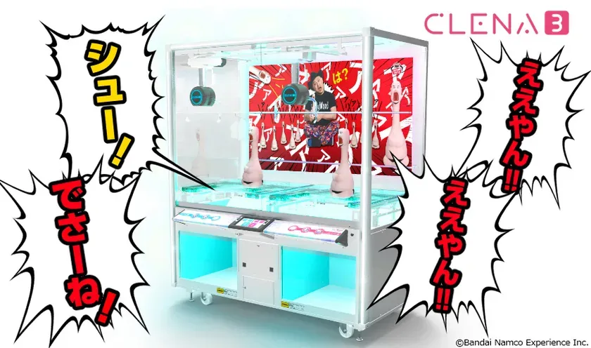 クレーンゲーム機CLENA3の画像。ゲーム機内には、奇妙な人形と驚いた表情の男性が描かれた背景が見える。吹き出しには「シュー！」「でさーね！」「ええやん！！」といったセリフが書かれている。