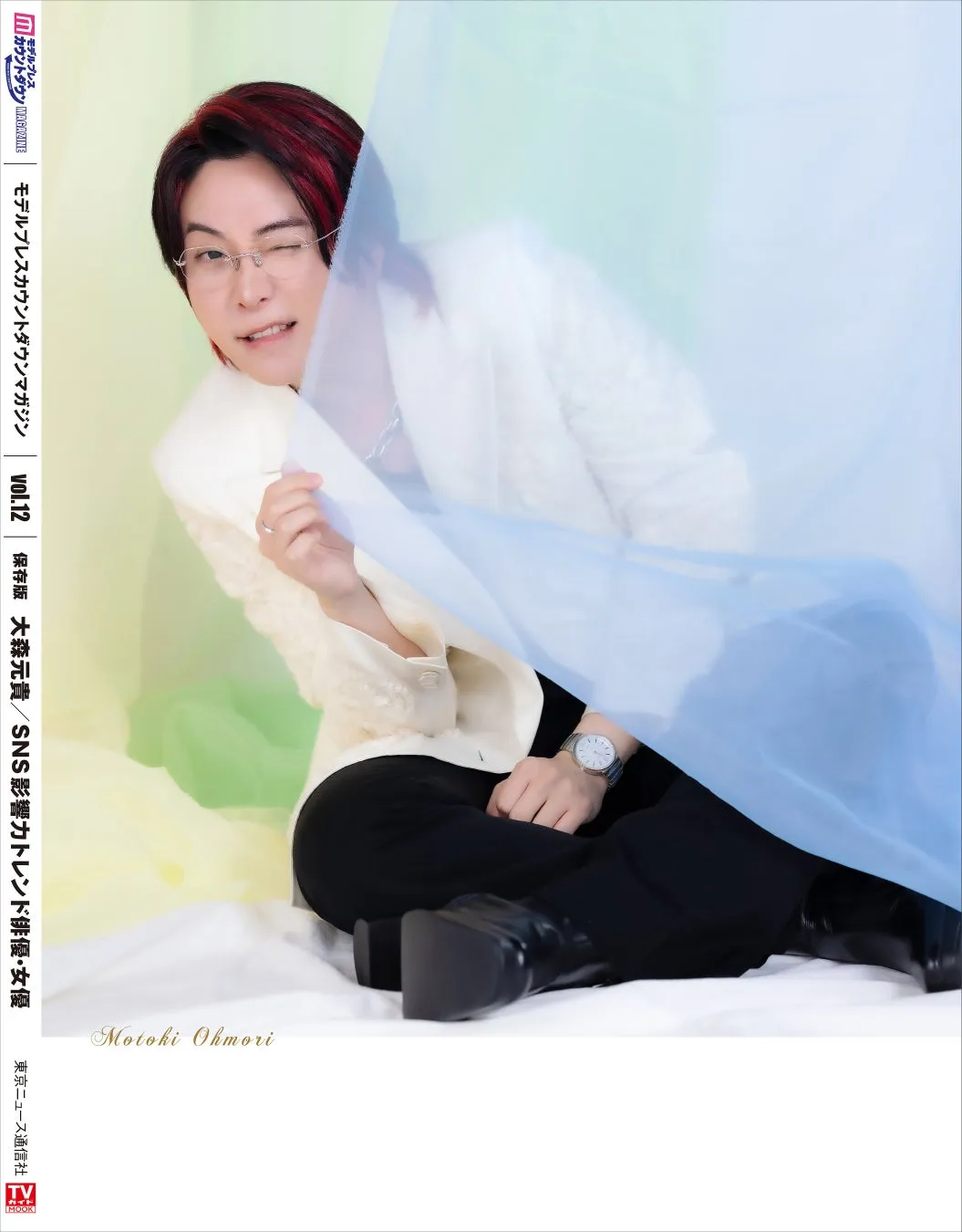 「今年の顔」Mrs. GREEN APPLE大森元貴が「フェーズ2完結」への率直な想いを独占告白!本日発売『モデルプレスカウントダウンマガジン vol.12』W表紙に登場 2 大森元貴が写った雑誌の表紙。水色の布の前に座り、ウィンクをしている。