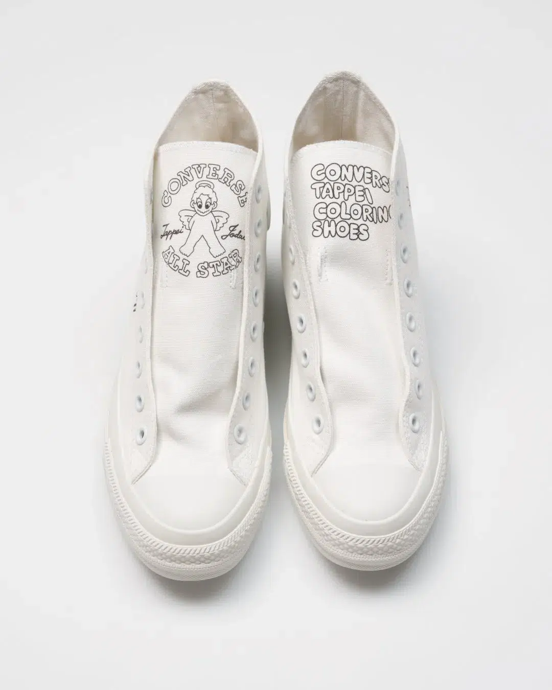 白いコンバースのシューズ。各シューズのタンにはキャラクターと文字がプリントされている。