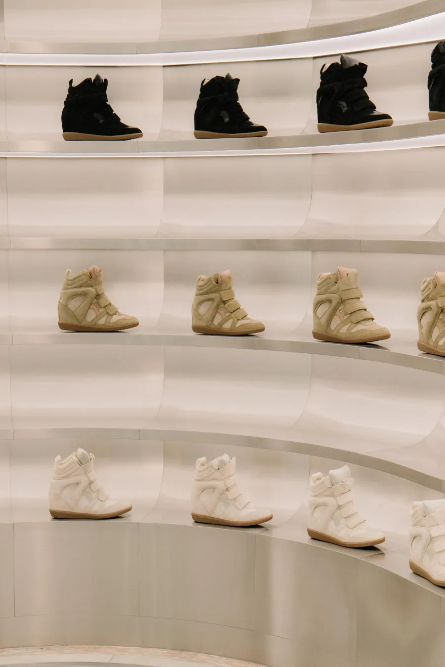 様々な色のスニーカーが並んだ棚の写真です。
