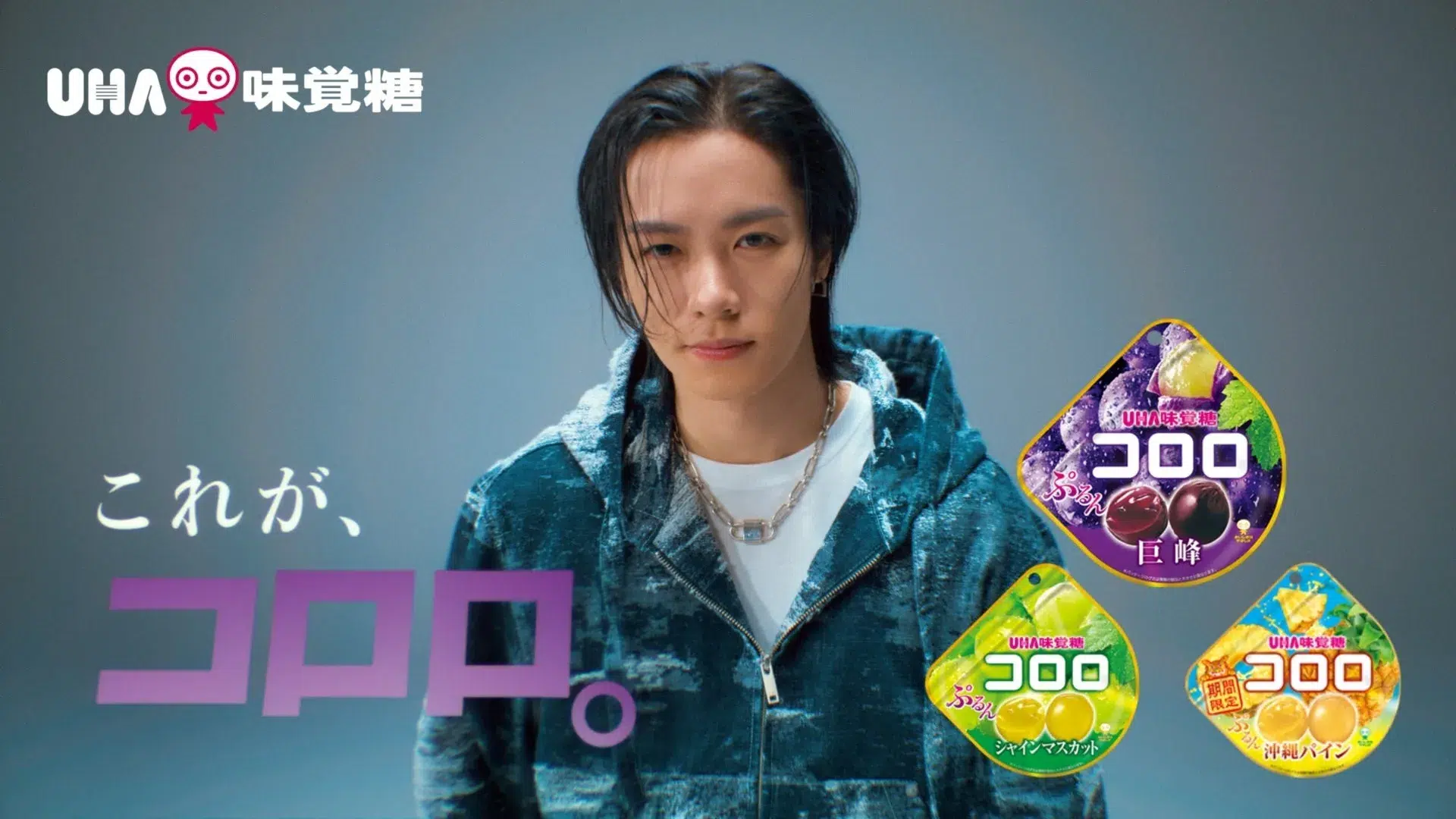 男性がUHA味覚糖コロロの広告に出演している画像。巨峰、シャインマスカット、沖縄パインの3種類のコロロが一緒に写っている。