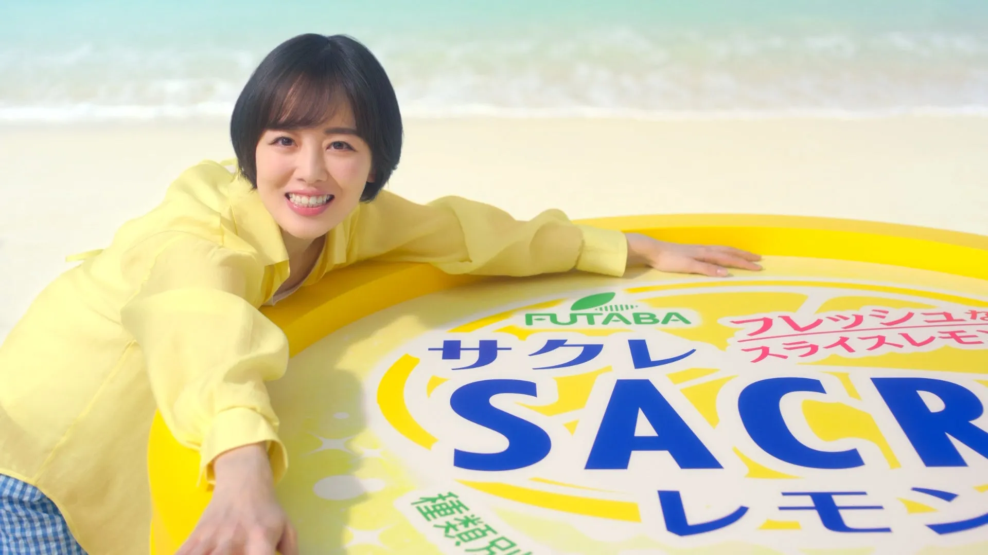 伊原六花がビーチで「だーい好き!」と告白!発売41年目の国民的アイス「サクレレモン」新CMが公開 2 浜辺で女性がサクレレモンの商品に寄り添い、笑顔を見せている様子