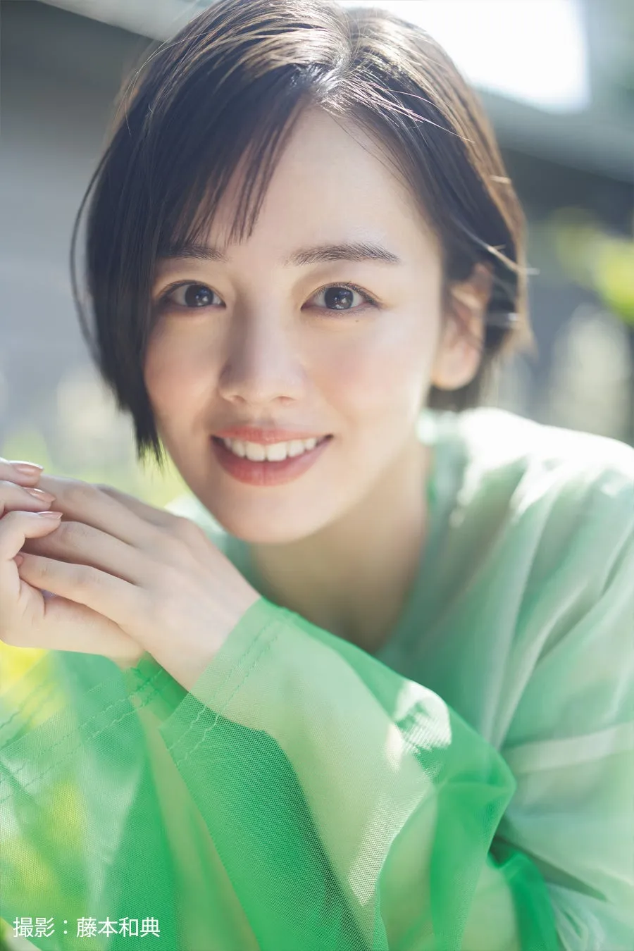 伊原六花がビーチで「だーい好き!」と告白!発売41年目の国民的アイス「サクレレモン」新CMが公開 3 笑顔が印象的な女性のポートレート。薄いグリーンの服を着て、カメラ目線で微笑んでいる。背景にはぼやけた緑の木々が見える。