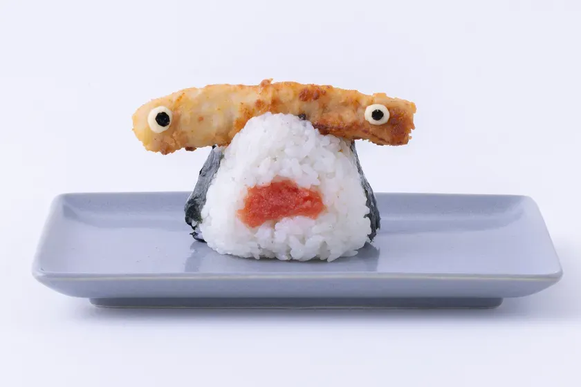 おにぎりがモンスターの顔のように見える写真。おにぎりの上には、揚げ物が目として配置されている。