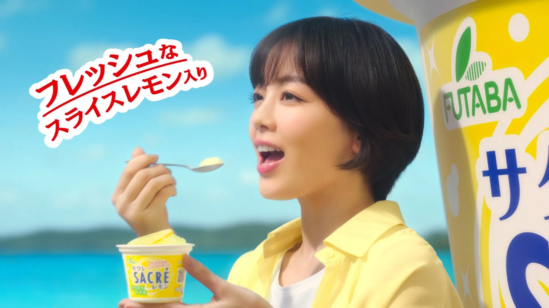 伊原六花がビーチで「だーい好き!」と告白!発売41年目の国民的アイス「サクレレモン」新CMが公開 4 女性がsacréレモンのアイスを食べている様子。背景には海と空が広がり、爽やかな印象を与える。