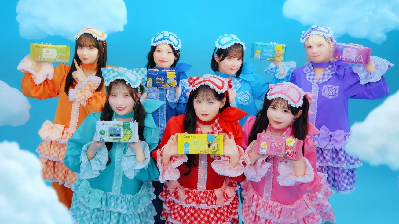 サボリーノ×CANDY TUNEが第2弾コラボ!限定ノベルティ&パジャマヒーロー動画で美肌と推し活を両立 17 カラフルなパジャマとアイマスクを着用した8人の女性が、サボリーノの朝用・夜用フェイスマスク製品を手にポーズをとっています。青い空と白い雲を背景に、明るく楽しい美容のプロモーションシーンが展開されています。