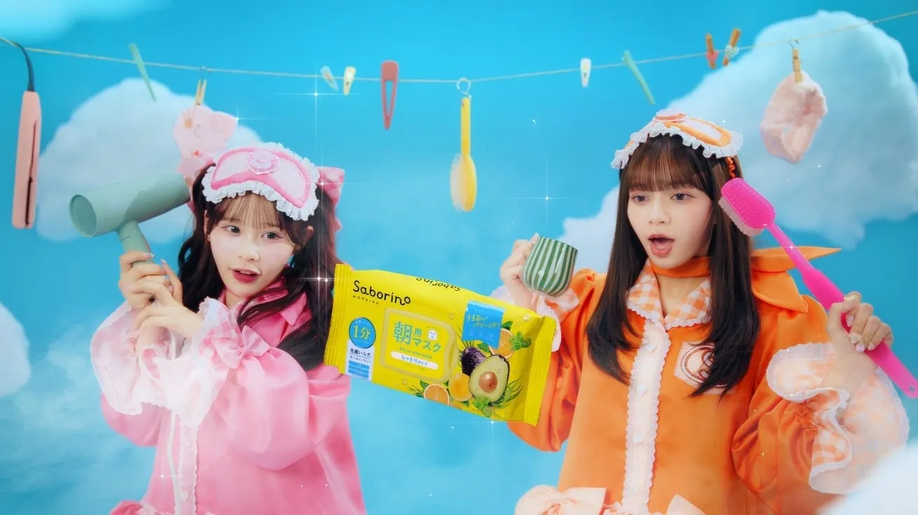 サボリーノ×CANDY TUNEが第2弾コラボ!限定ノベルティ&パジャマヒーロー動画で美肌と推し活を両立 15 パジャマ姿の2人の女性がSaborinoの朝用マスクを持って、朝の準備を楽しむ様子を描いたカラフルな広告画像です。ドライヤーやブラシなど、日常の美容アイテムが散りばめられています。