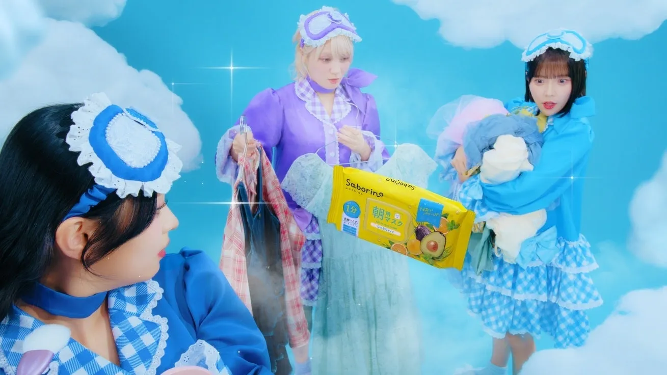 サボリーノ×CANDY TUNEが第2弾コラボ!限定ノベルティ&パジャマヒーロー動画で美肌と推し活を両立 16 青い空と雲を背景に、パジャマ風の可愛らしい衣装を身につけた3人の女性が写っています。中央の女性はサボリーノの朝用シートマスクを持ち、全体的に夢のような雰囲気の広告ビジュアルです。