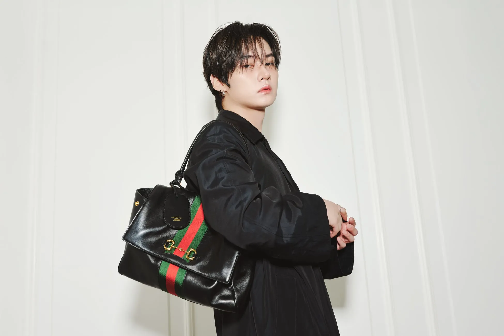 Stray Kidsリノがグッチ「Generation Gucci」で魅せた新境地!唯一無二の洗練ルック2選を徹底解剖 1 黒いジャケットを着てグッチのバッグを持った男性のポートレート